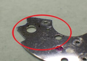 カルティエ カリブル ドゥ カルティエ 自動巻き受けの裏には劣化したグリスが散らばっていました